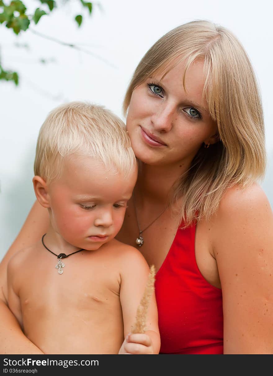 Portrait - mother with the small son against a summer garden