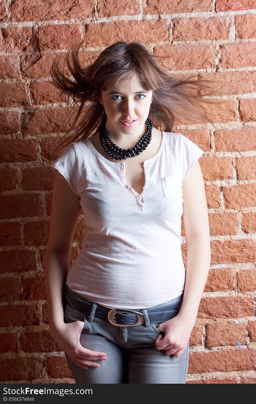 Portrait of a beautiful girl on a background of brick wall