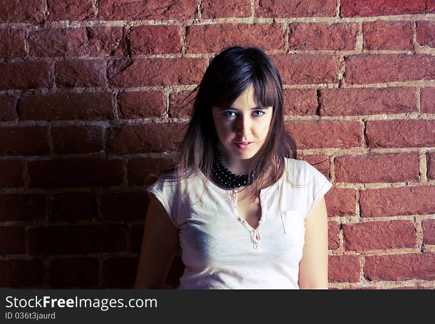 Portrait of a beautiful girl on a background of brick wall