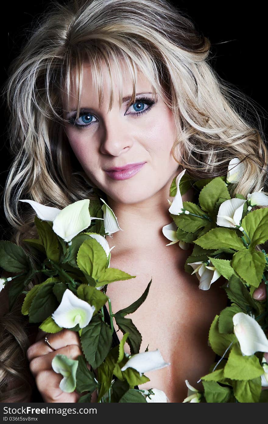 Portrait of a beautiful, blue-eyed blond woman with silk floral garland around her neck. Portrait of a beautiful, blue-eyed blond woman with silk floral garland around her neck.