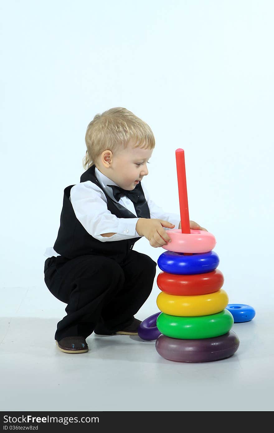 The playing boy in a suit with a bright toy