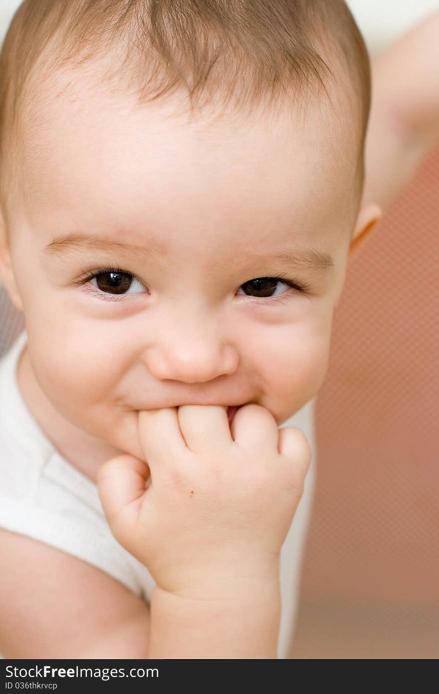 Fun caucasian baby with finger in his mouth, home play