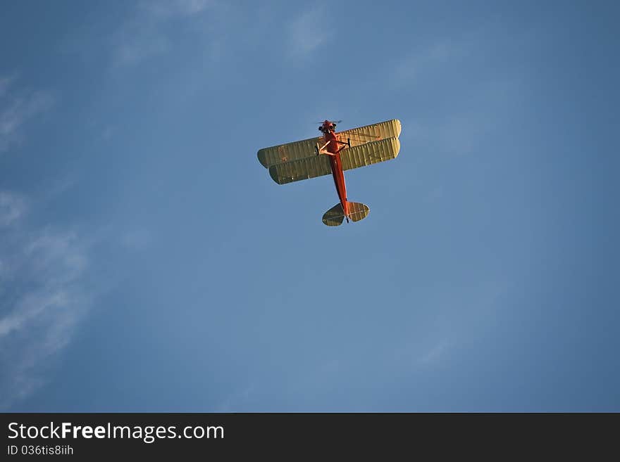 An open cockpit red student prince biplane in flight