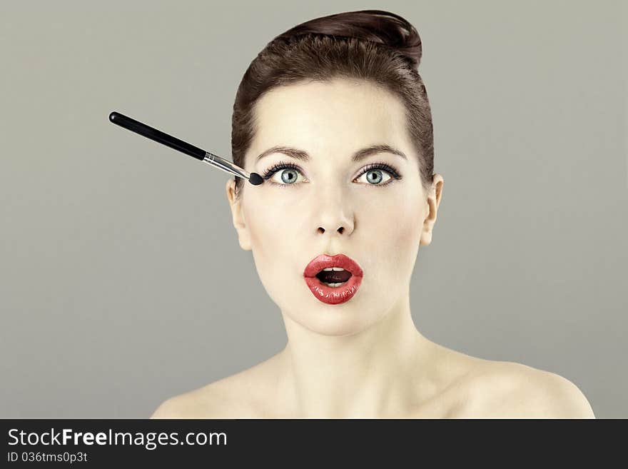 Portrait of beautiful woman doing makeup