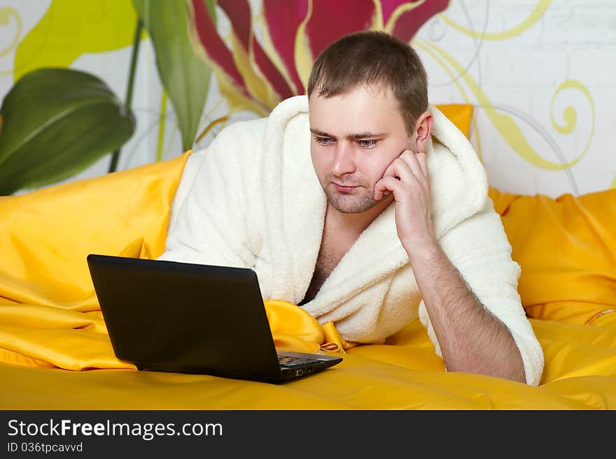 Portrait Of A Relaxed Young Guy Using Laptop