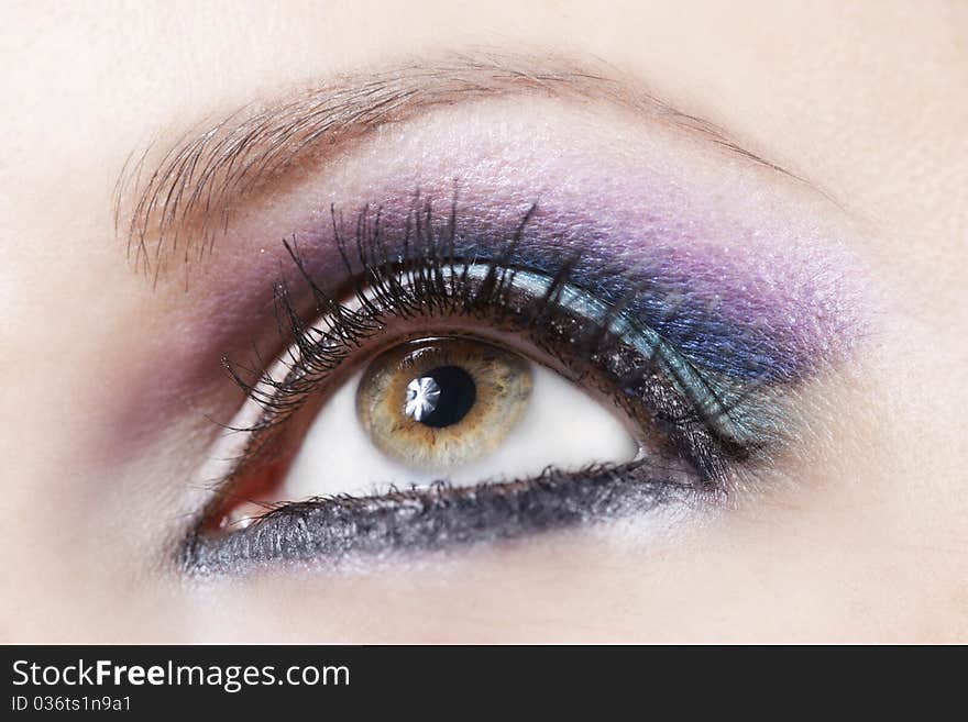 Macro shot of woman eye with violet and blue bright make-up. Macro shot of woman eye with violet and blue bright make-up