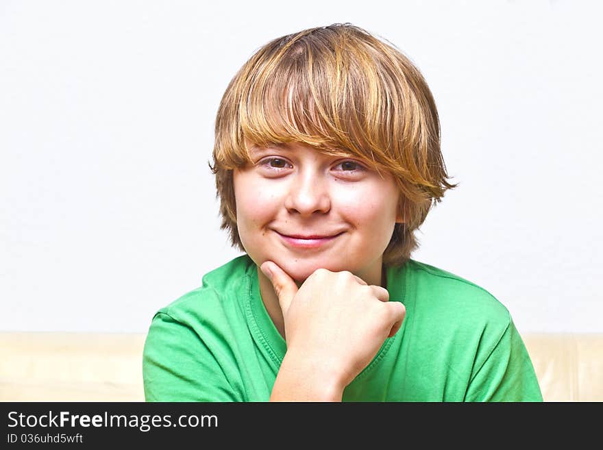 Smiling boy sitting on a sofa at home