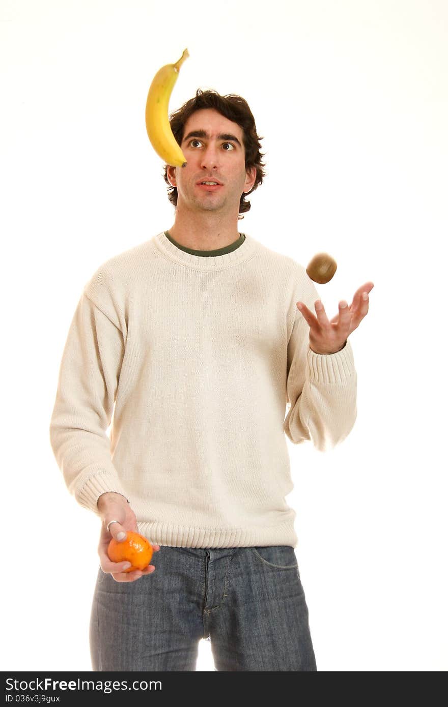 Young man juggling fruit in a white background. Young man juggling fruit in a white background