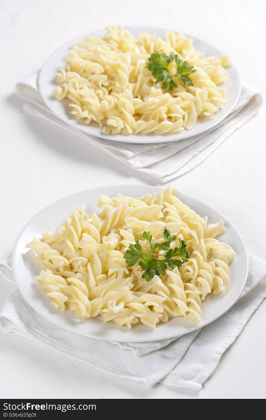 Two plates of pasta with parsley