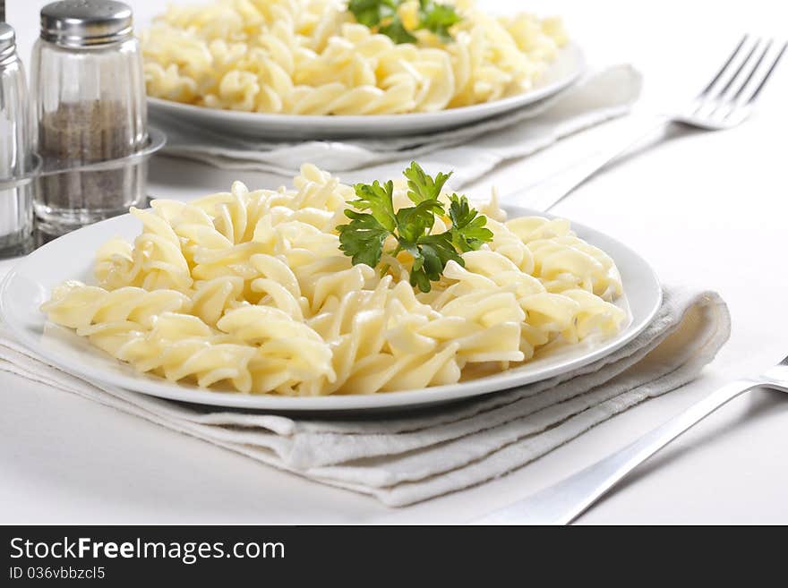 Two plates of pasta with parsley