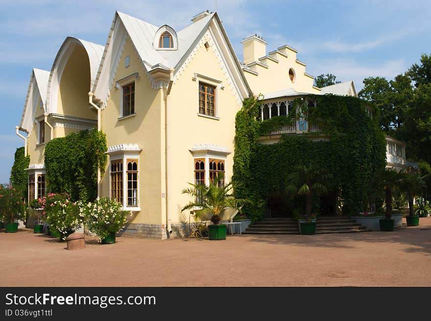 Beautiful house with ivy on a background of blue sky summer sunny day. Beautiful house with ivy on a background of blue sky summer sunny day