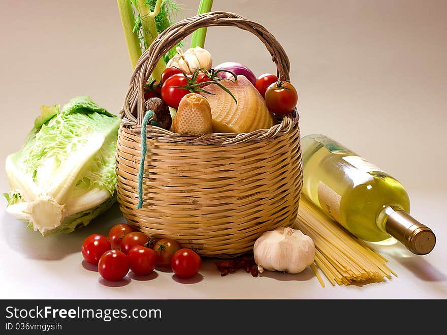 Basket with vegetables and vine with grey background. Basket with vegetables and vine with grey background