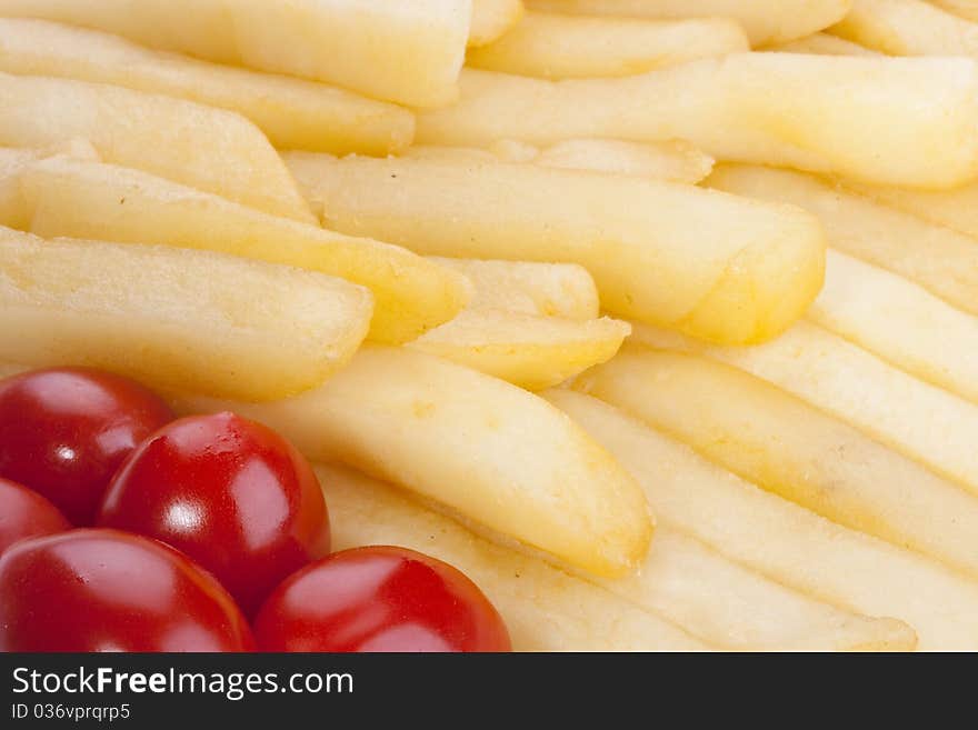 The fried potato is laid out in a plate with tomatoes.