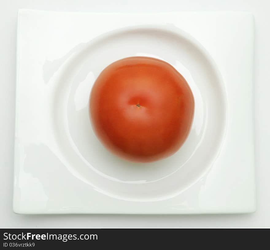 Raw tomato on plate-top view. Raw tomato on plate-top view.