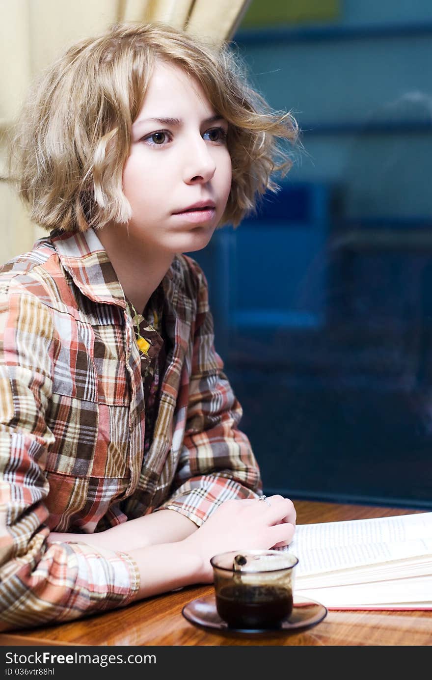 Sensual girl reading a book and drinking a coffee in a coffee shop. Sensual girl reading a book and drinking a coffee in a coffee shop