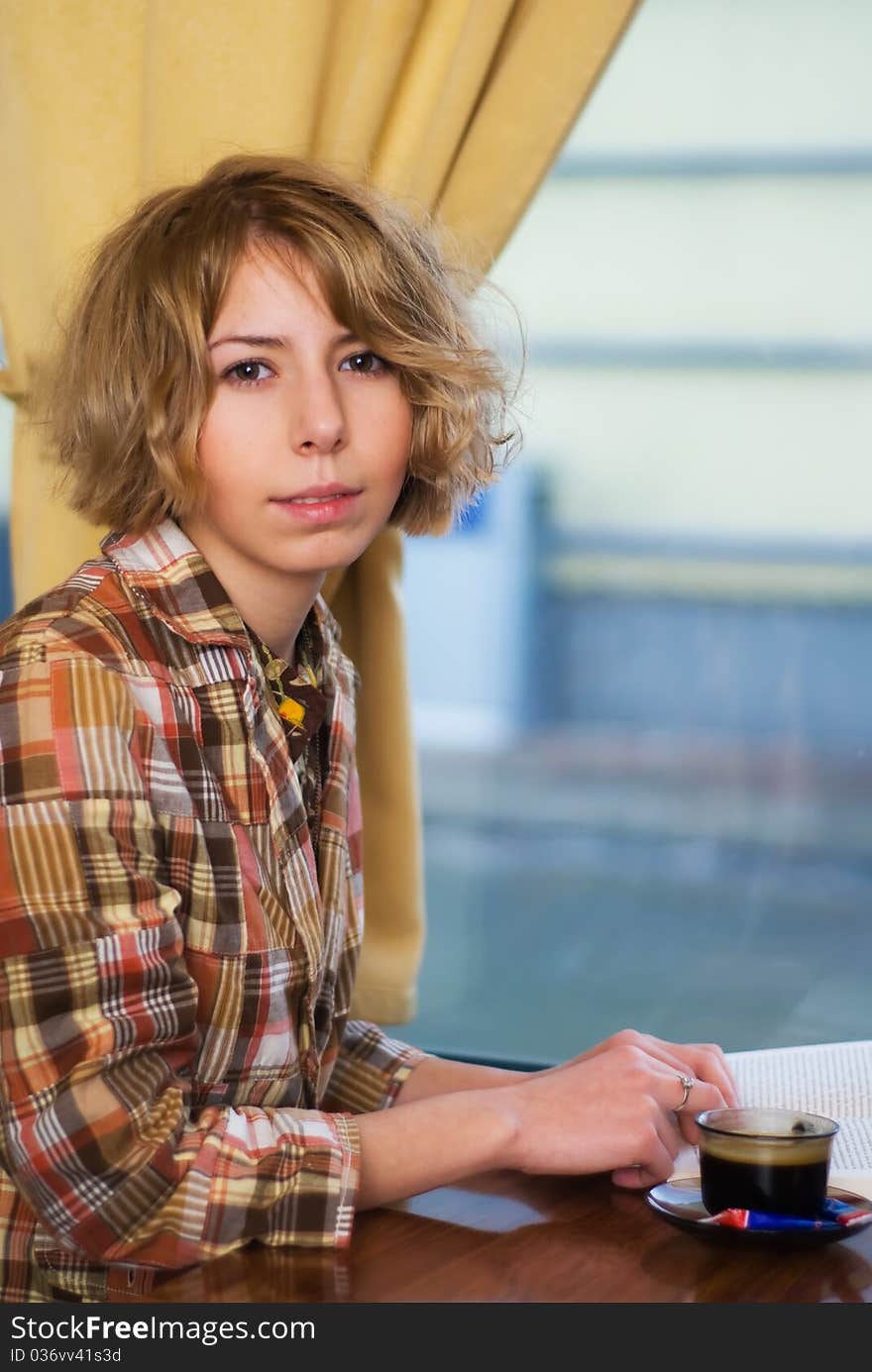 Sensual girl reading a book and drinking a coffee in a coffee shop. Sensual girl reading a book and drinking a coffee in a coffee shop