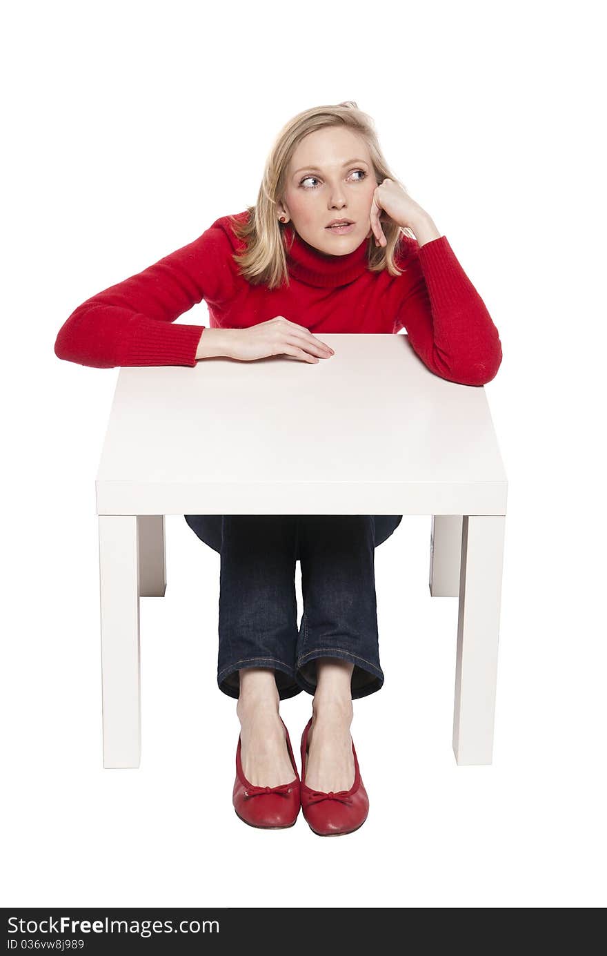 Young woman sitting at funny small desk