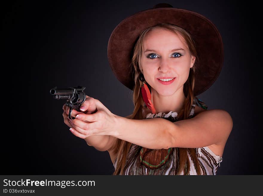 The American Indian girl in a cowboy's hat holds a pistol