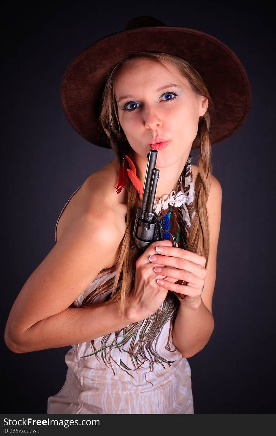 The American Indian girl in a cowboy's hat holds a pistol