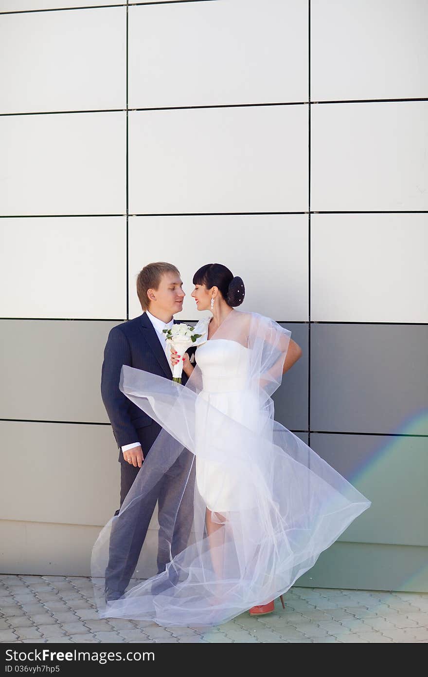 Bride and groom by the wall. Bride and groom by the wall