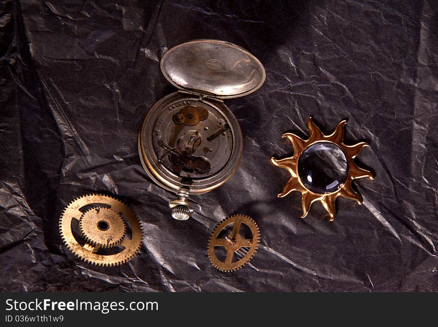 Composition of old clockwork and little golden sun on the black paper. Composition of old clockwork and little golden sun on the black paper