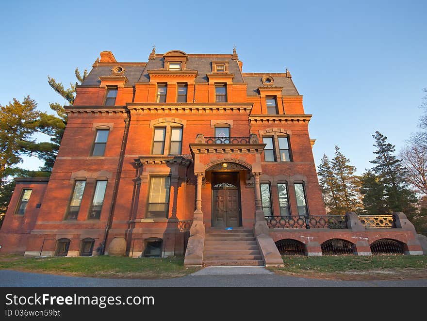 A brick Victorian parish building with the morning sunlight on it.