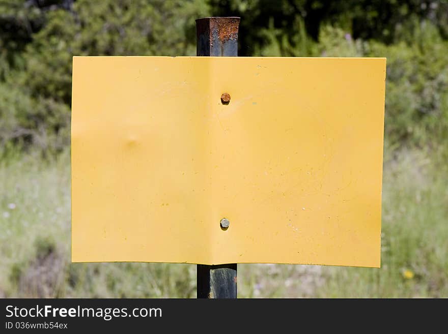 Metal empty yellow sign in the countryside