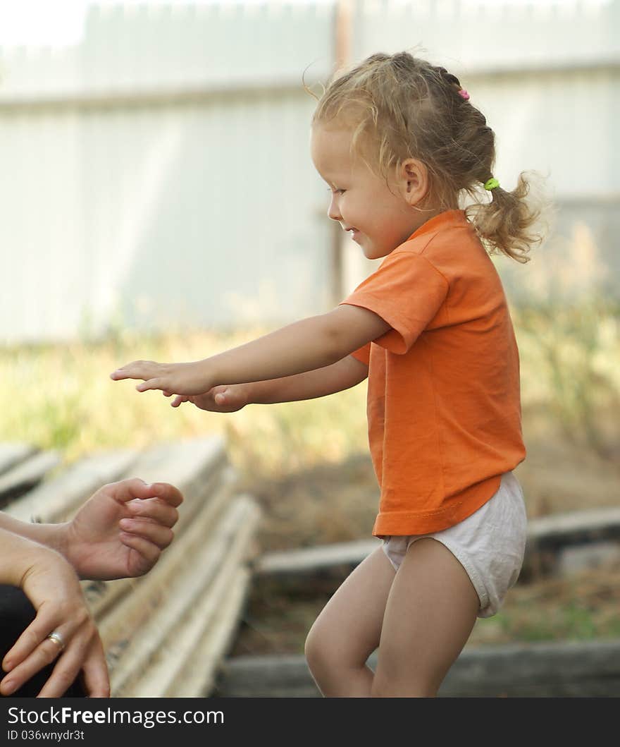 Girl under the supervision of an adult woman. Girl playing on a sunny day.