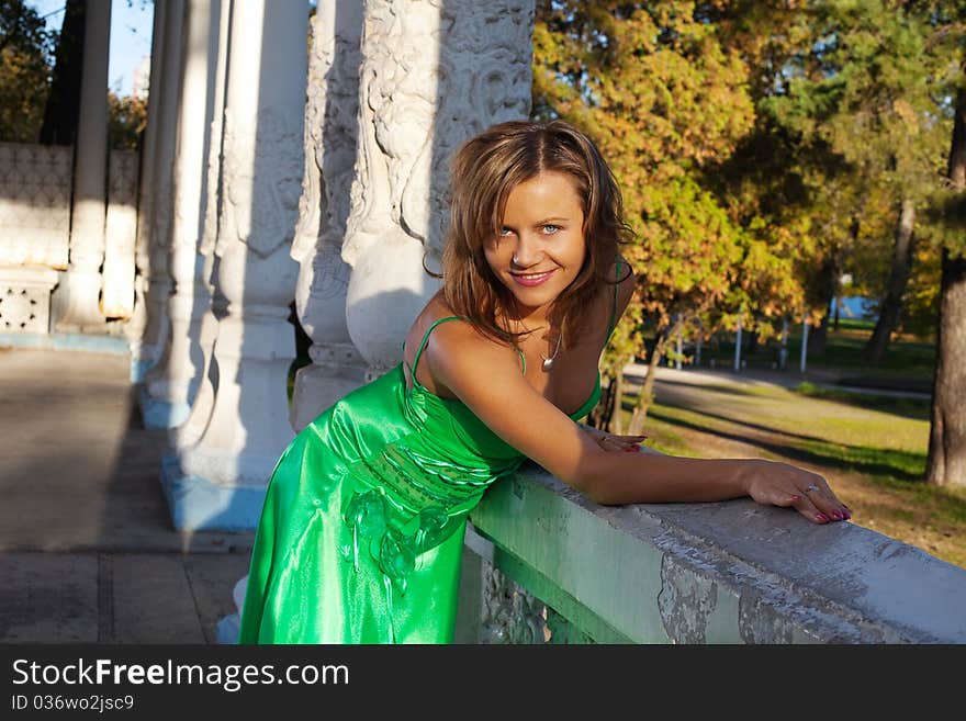 Woman in green clothes smile on autumn sunset