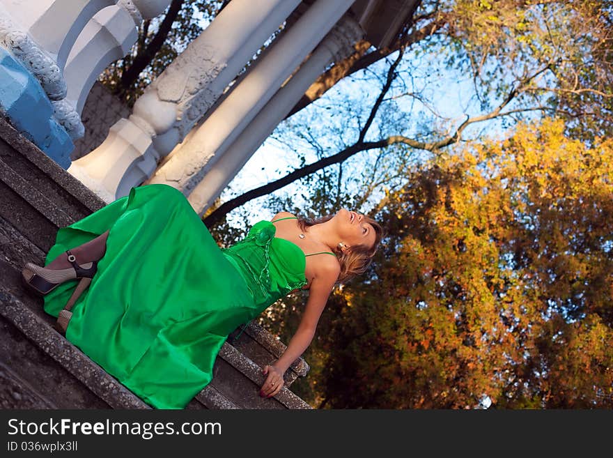 Beauty woman in green clothes sit on stair