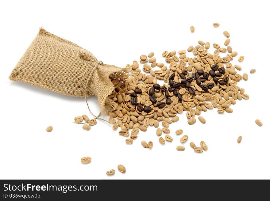 Roasted beans spelling the word coffee with the background of unroasted coffee beans. Isolated over white