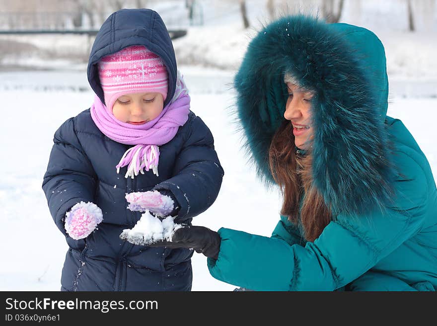 Mother and  kid having fun outdoors on  winter day