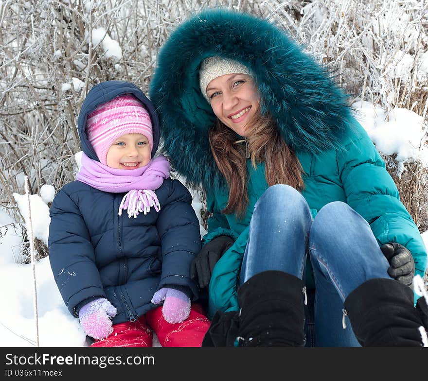 Mother and  kid having fun outdoors on  winter day