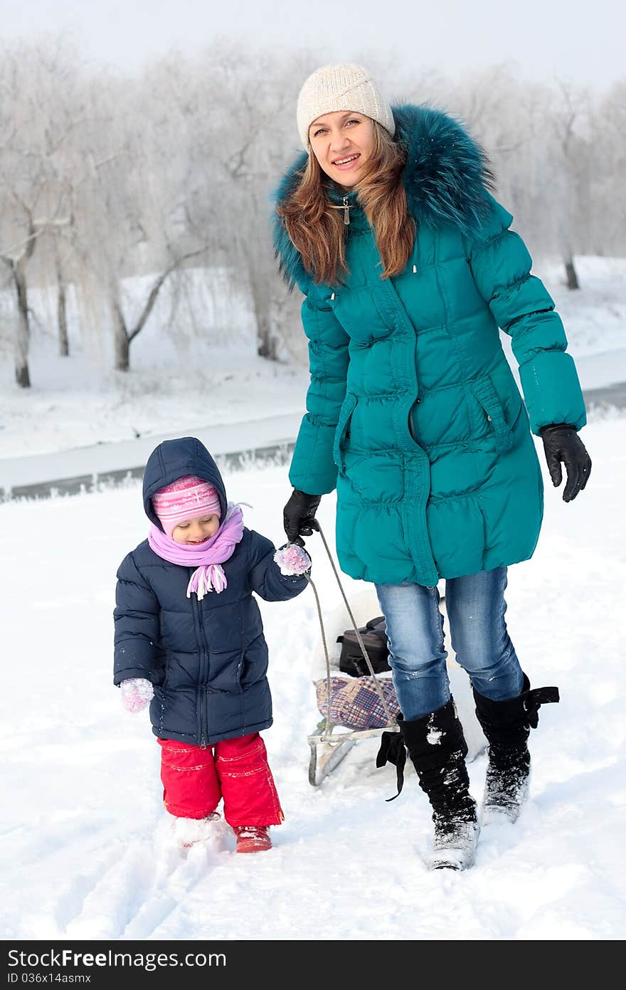 Mother and  kid having fun outdoors on  winter day