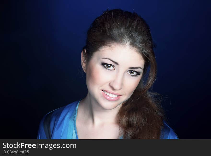 Beautiful young smiling girl on the blue background