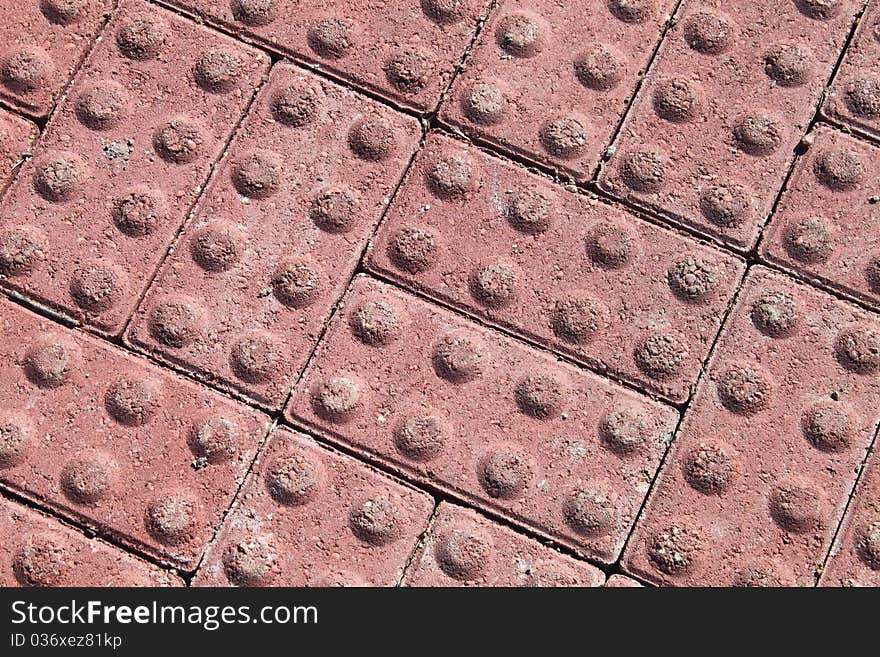 A pattern of brick red building blocks with eight circles each. A pattern of brick red building blocks with eight circles each.