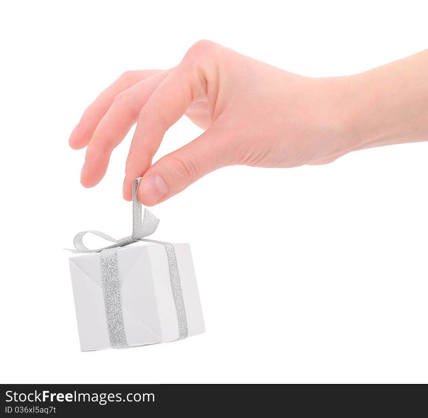 Woman's hand with a small white gift box with silver ribbon isolated on white background. Woman's hand with a small white gift box with silver ribbon isolated on white background.