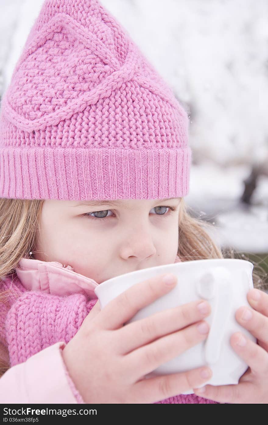 Girl drinking tea outside in the snow