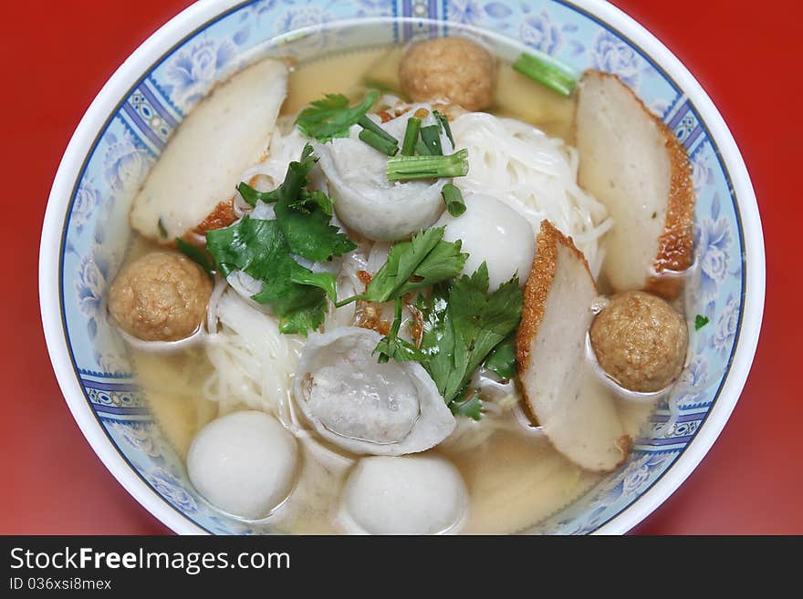 Wide rice noodle soup with vegetables and meat