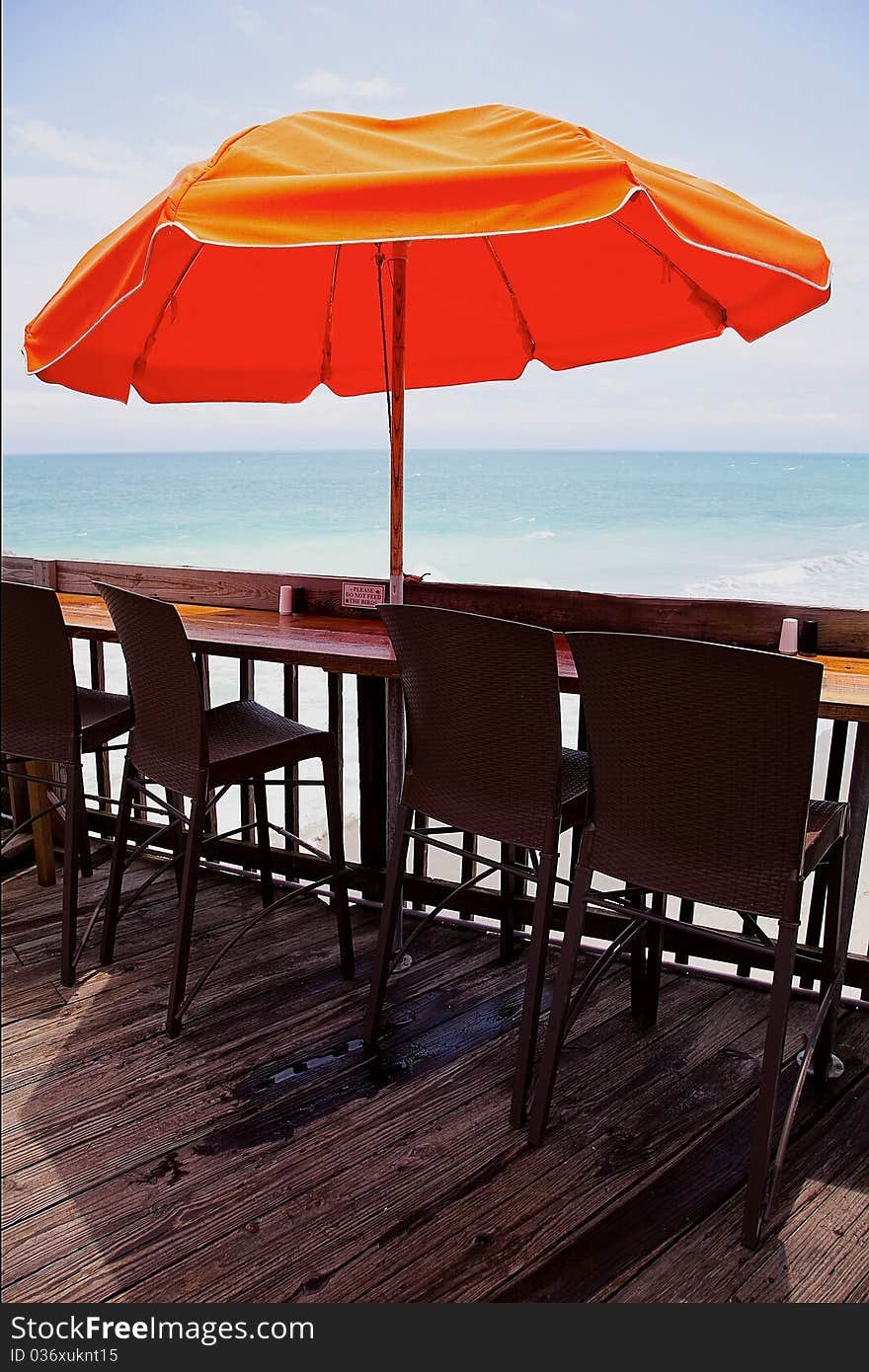 Chairs under an umbrella on a pier