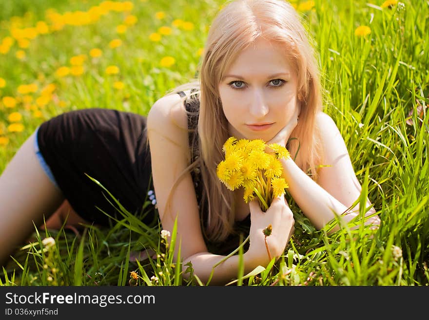 Beautiful woman with dandelions in hands