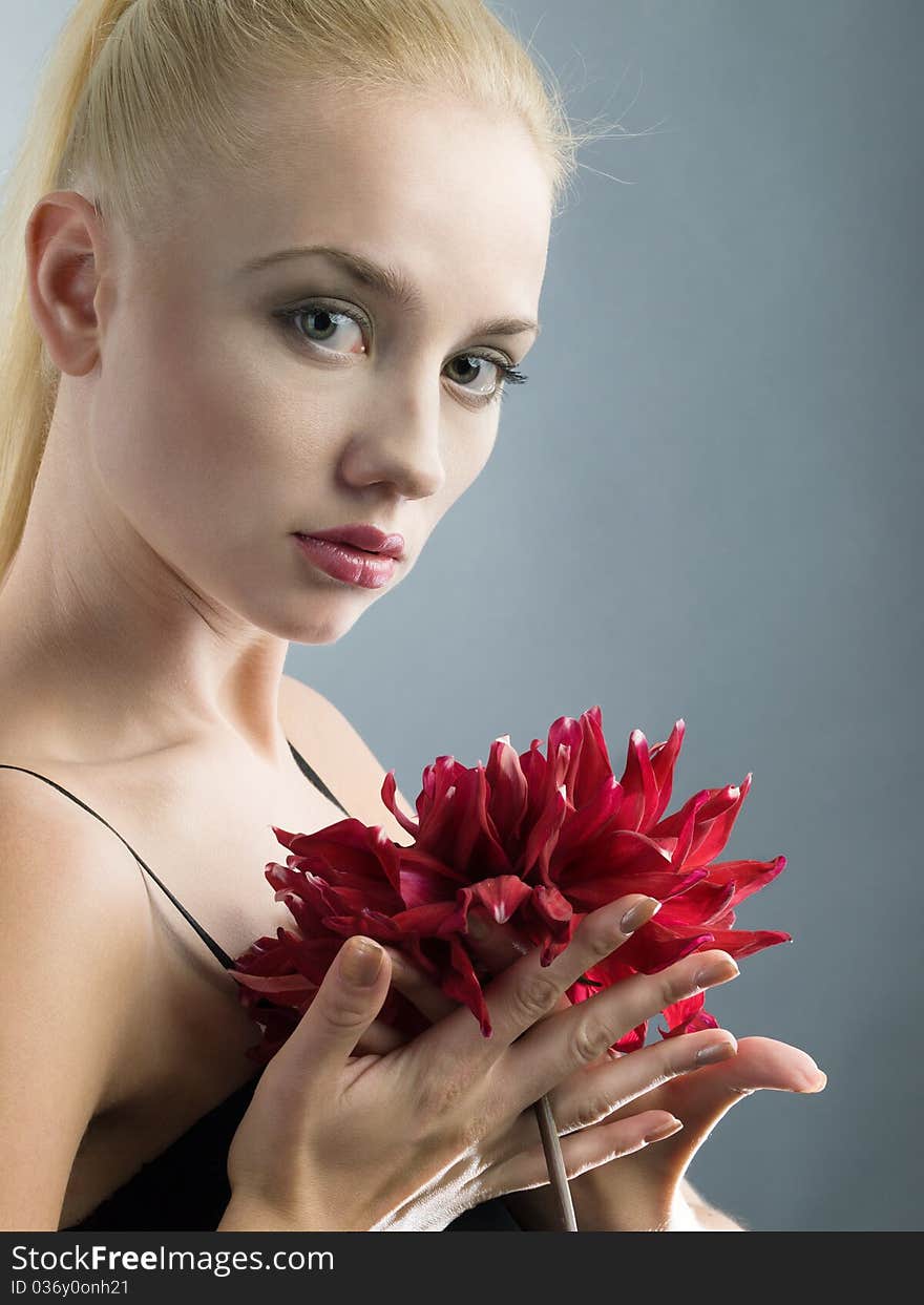 Elegant blonde girl in black dress and red flower at hand. Elegant blonde girl in black dress and red flower at hand