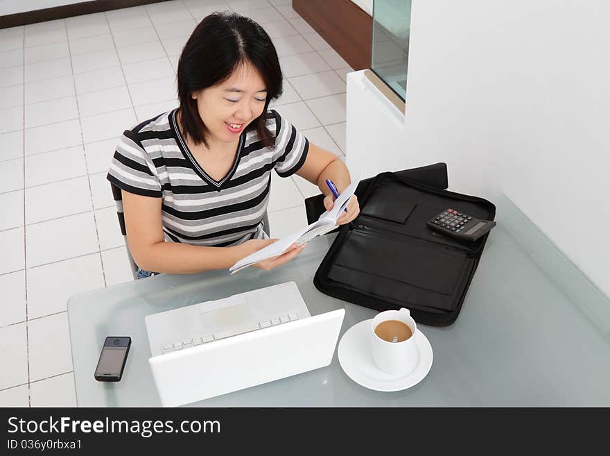 An Asian woman working from home. An Asian woman working from home