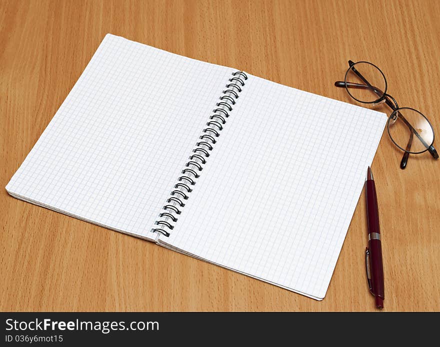 Notebook, glasses and pen on the table. Notebook, glasses and pen on the table.