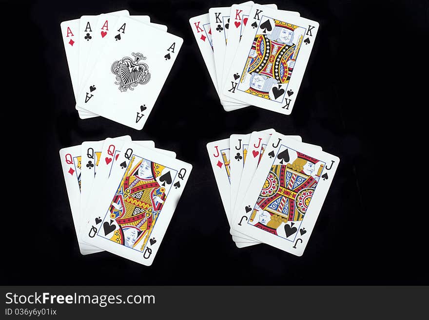 4 combinations of winning poker hands in spades, clubs, diamonds and hearts in a royal flush, isolated on black. 4 combinations of winning poker hands in spades, clubs, diamonds and hearts in a royal flush, isolated on black