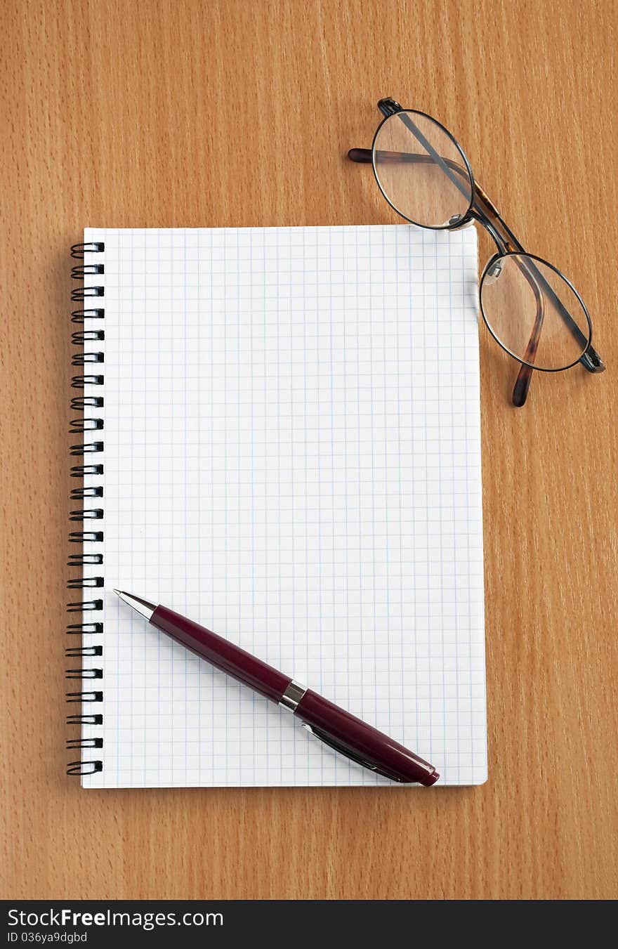 Notebook, glasses and pen on the table. Notebook, glasses and pen on the table.