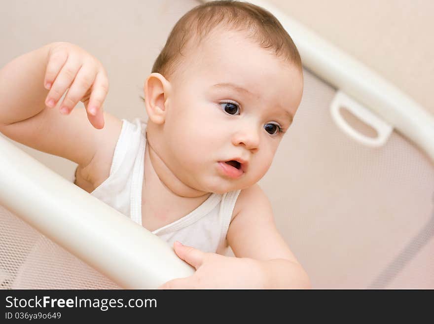 Cute caucasian baby playing in manege. Cute caucasian baby playing in manege