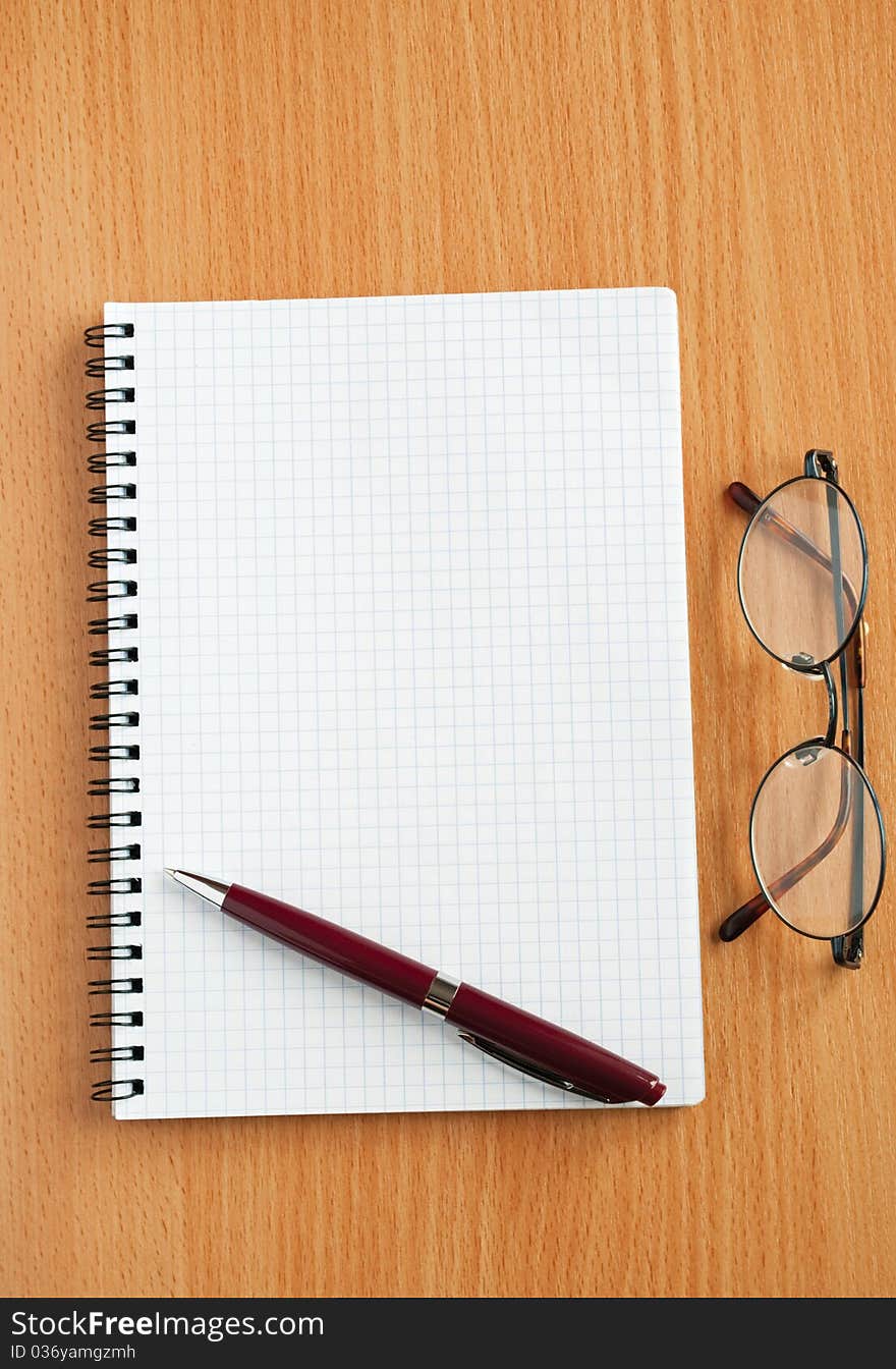 Notebook, glasses and pen on the table. Notebook, glasses and pen on the table.