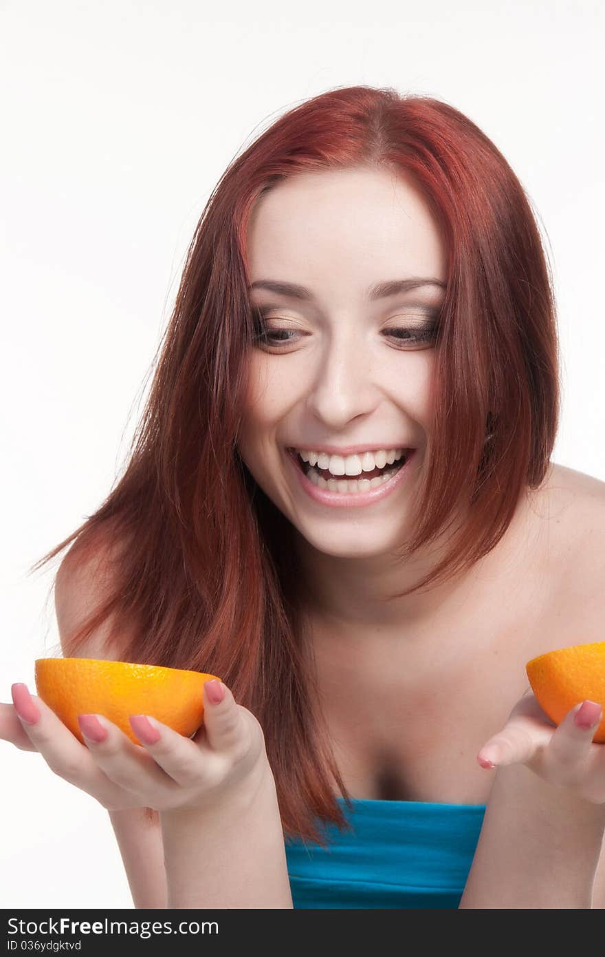 A beautiful redhead woman holding a half of orange isolated on white. A beautiful redhead woman holding a half of orange isolated on white