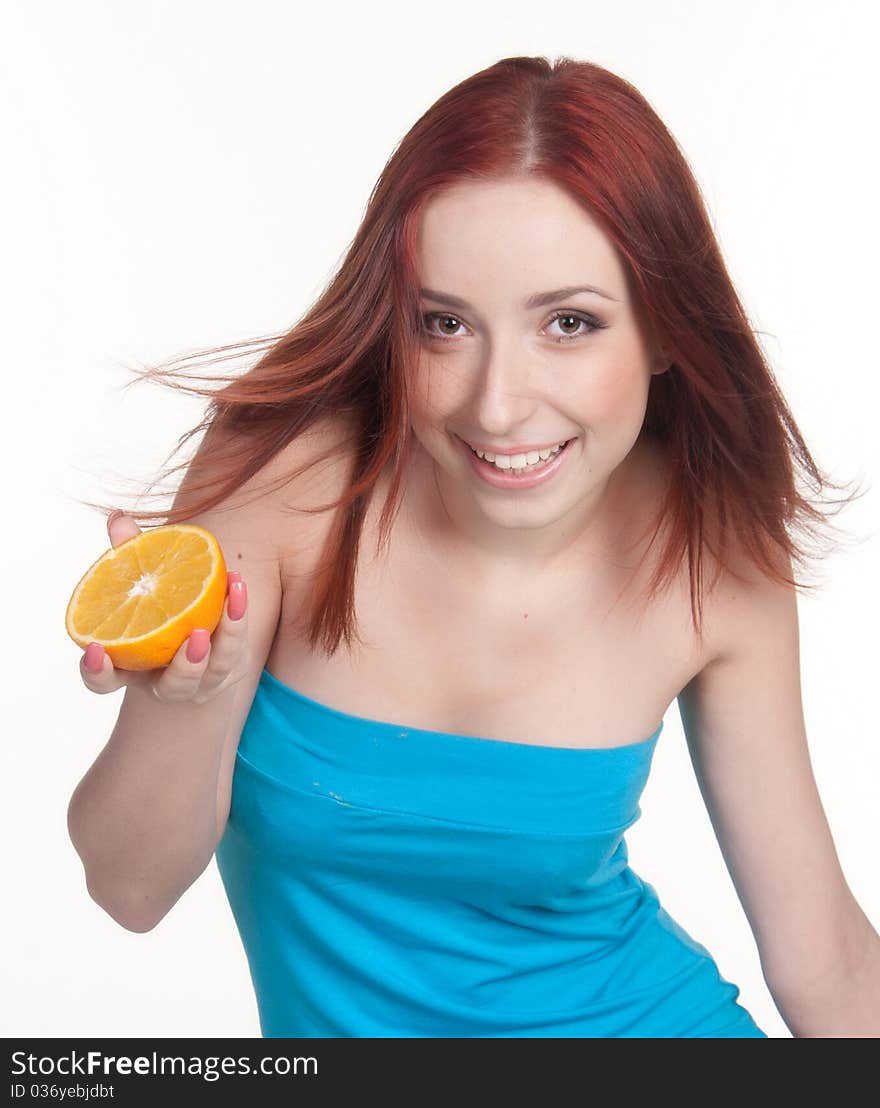 A beautiful redhead woman holding a half of orange isolated on white. A beautiful redhead woman holding a half of orange isolated on white